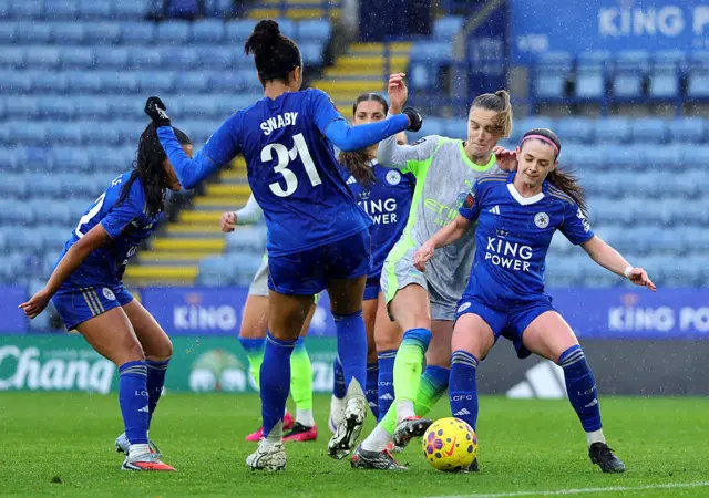 Vivianne Miedema of Manchester City is challenged by Chantelle Swaby (C) and Nelly Las of Leicester City (R) during the Barclays Women's Super League match between Leicester City and Manchester City at The King Power Stadium on December 07, 2025 in Leicester, England.