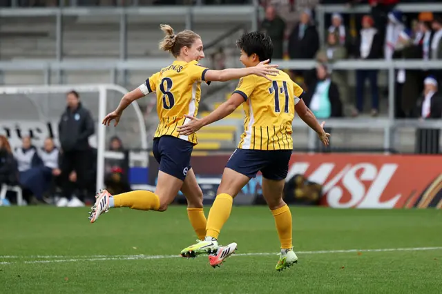 Kiko Seike of Brighton & Hove Albion (R) celebrates scoring her team's first goal with teammate Maisie Symonds (L) during the Barclays Women's Super League match between London City Lionesses and Brighton & Hove Albion at Copperjax Community Stadium on December 07, 2025 in Bromley, England.