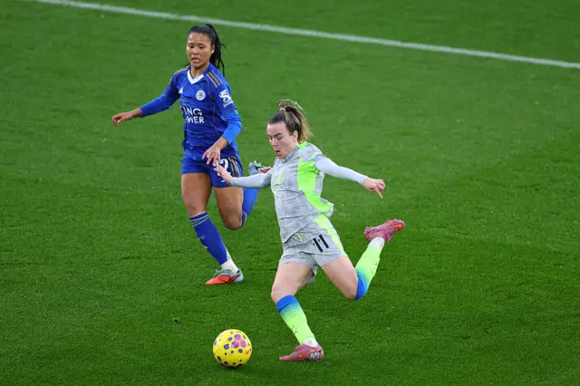 Lauren Hemp of Manchester City crosses the ball under pressure from Asmita Ale of Leicester City during the Barclays Women's Super League match between Leicester City and Manchester City at The King Power Stadium on December 07, 2025 in Leicester, England.