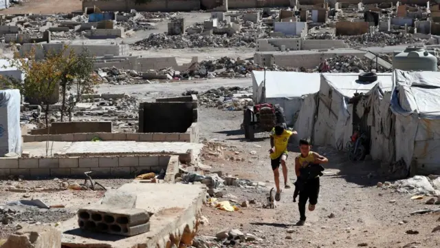Syrian refugee children run outside their makeshift shelters of the Syrian refugee camp in Lebanon.