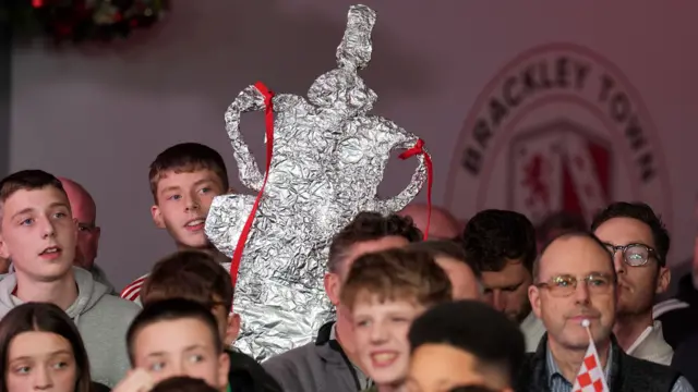 Brackley fans hold up a tinfoil FA Cup