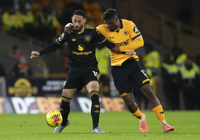 Manchester United's Matheus Cunha (left) and Wolverhampton Wanderers' Emmanuel Agbadou battle for the ball during the Premier League match at Molineux Stadium, Wolverhampton. Picture date: Monday December 8, 2025.