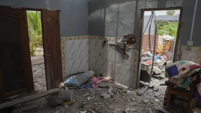 The inside of a damaged house, filled with debris