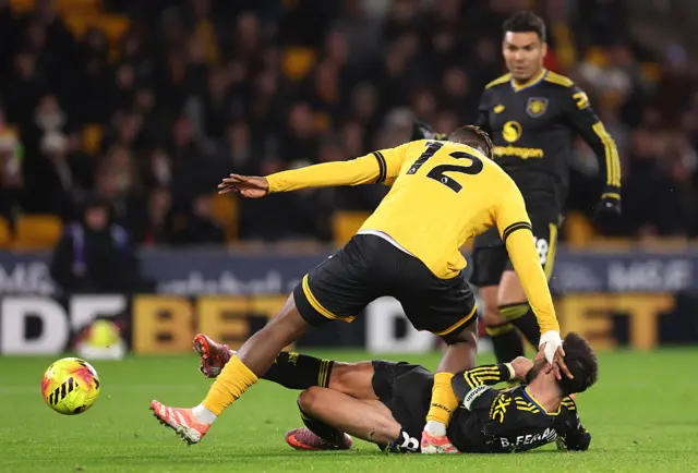 Bruno Fernandes of Manchester United scores his team's first goal whilst under pressure from Emmanuel Agbadou of Wolverhampton Wanderers during the Premier League match between Wolverhampton Wanderers and Manchester United at Molineux on December 08, 2025 in Wolverhampton, England. (
