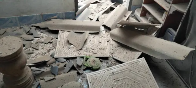 Debris strewn across a damaged house