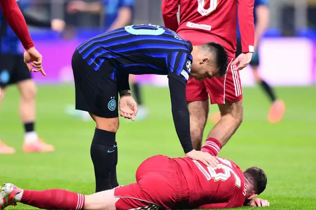 Lautaro Martinez checks on Liverpool's Scottish defender #26 Andrew Robertson
