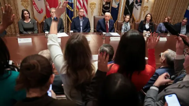 銃撃の前でジャーナリストたちは手を挙げ、ホワイトハウスの閣僚テーブルに座るドナルド・トランプ大統領に質問した。