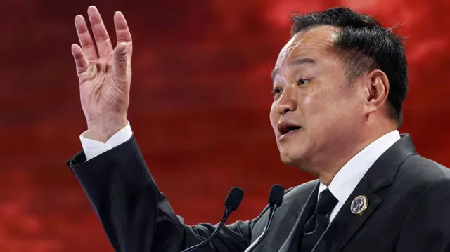 Man raises hand against red backdrop