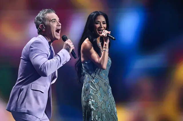 Robbie Williams and US singer Nicole Scherzinger perform on stage during the draw for the 2026 FIFA Football World Cup