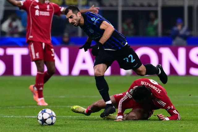 Liverpool's Hungarian midfielder #08 Dominik Szoboszlai pulled tto the ground by Inter Milan's Armenian forward #22 Henrikh Mkhitaryan