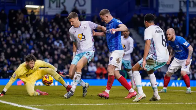 James Trafford and the Burnley defence stop Portsmouth's Colby Bishop getting a shot away