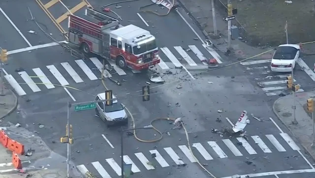 Debris in front of a fire truck and a few cars parked around it