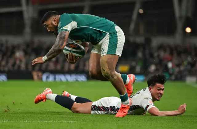 Bundee Aki jumping over Marcus Smith