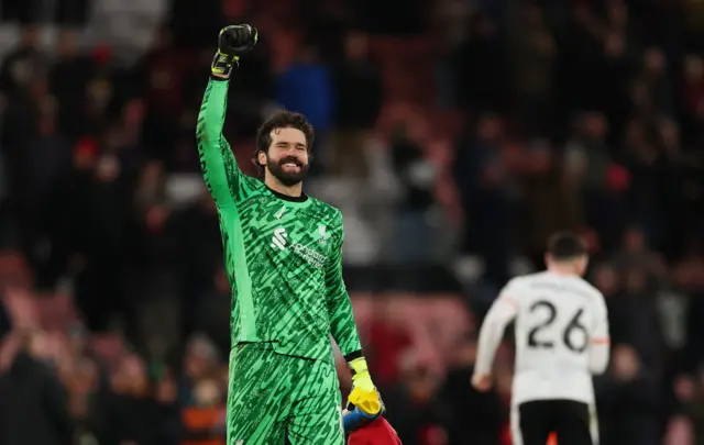 Alisson holds his fist to the sky