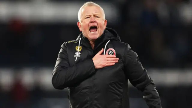 Sheffield United manager Chris Wilder places his hand on the club badge in celebration