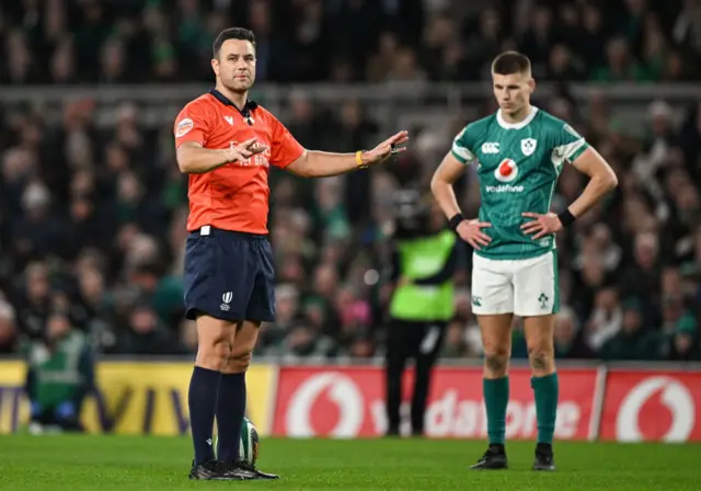 Referee with his hands up explaining something