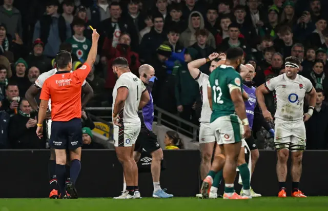 Referee showing a yellow card to England's Marcus Smith