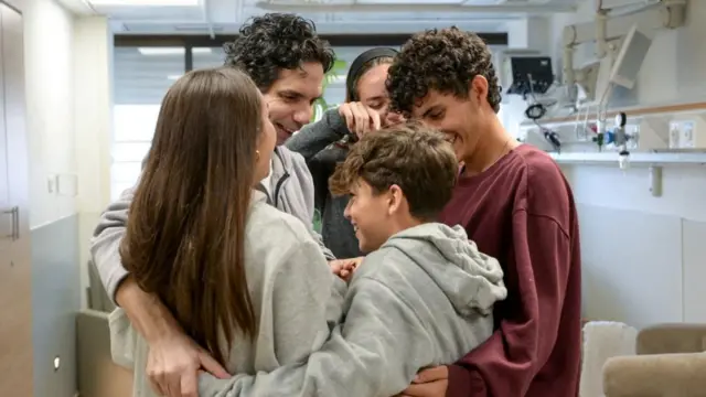 Ofer Kalderon surrounded by his family who are smiling.