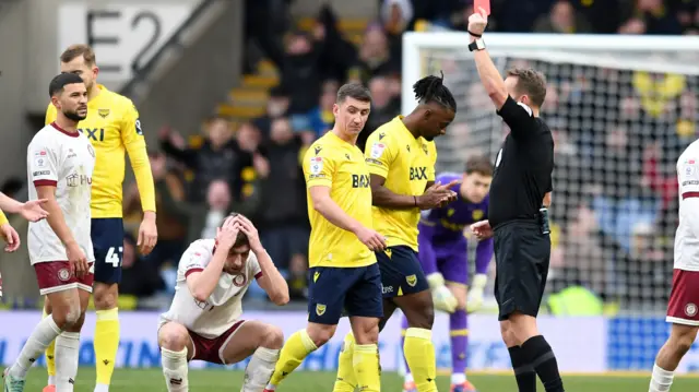 Bristol City midfielder Joe Williams has his head in his hands as he's shown a red card