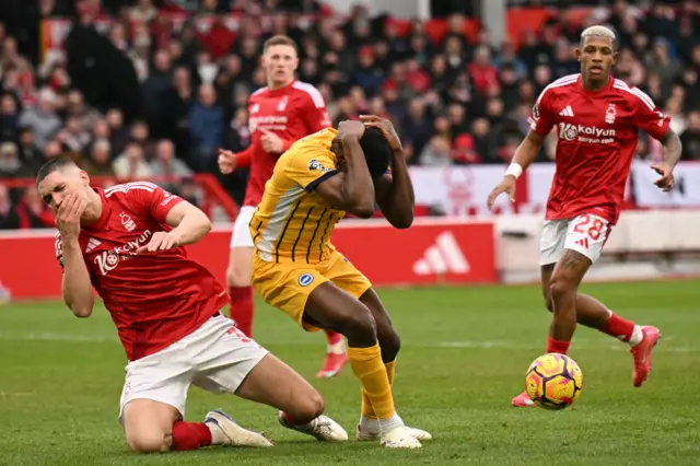 Welbeck holds his head after a collision with Milenkovic