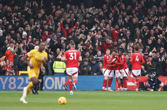 Forest players celebrate as a Brighton player trudges back to kick off