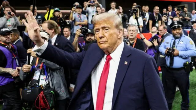 U.S. President Donald Trump greets people as he attends the Super Bowl