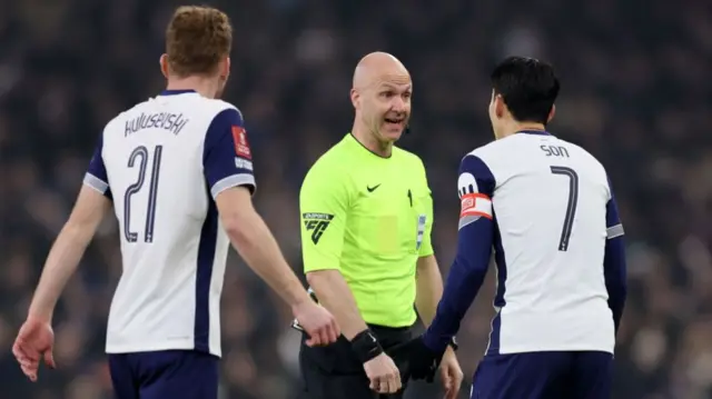 Referee Anthony Taylor speaks with Tottenham players during Sunday's match at Aston Villa