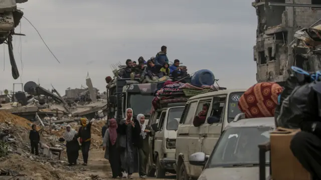 A line of cars, with belongings strapped to the top of each, is seen as Palestinians make their way home to northern Gaza since the ceasefire between Hamas and Israel was announced