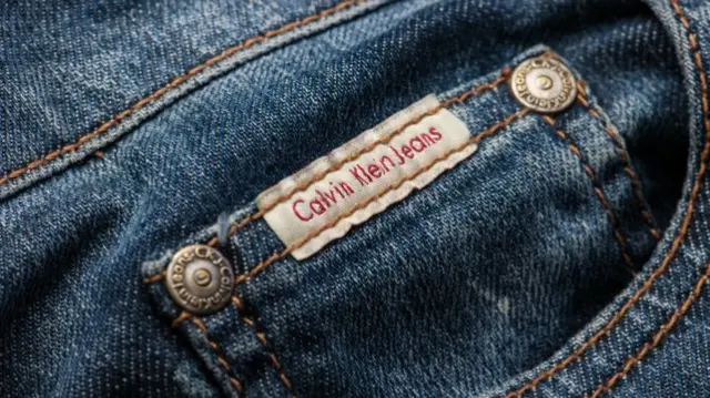 A pair of light denim jeans with a label sewed in which says 'Calvin Klein Jeans'