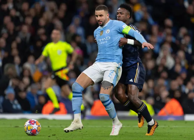 Kyle Walker shields the ball from Vinicius Jnr as Manchester City play Real Madrid in the Champions League