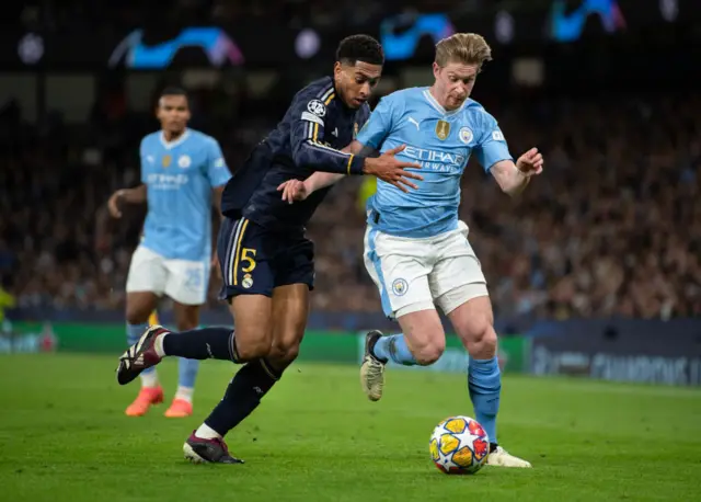 Bellingham and De Bruyne duel for the ball