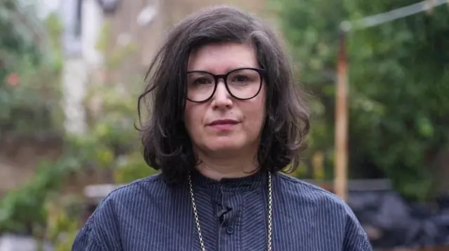 Sharone Lifschitz in a blue striped shirt and necklace