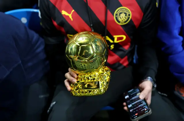 Fan holds a replica ballon dor trophy