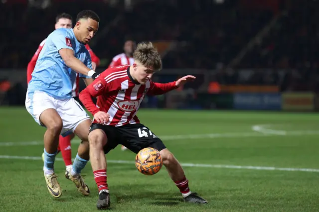 Nottingham Forest's German defender #17 Eric da Silva Moreira (L) fights for the ball with Exeter City's English midfielder #47 Jake Thomas Richards during the English FA Cup fourth round football match between Exeter City and Nottingham Forest at St James Park in Exeter, south west England, on February 11, 2025.