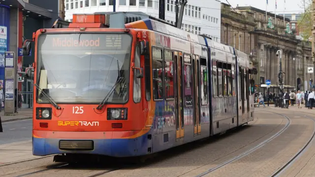 A tram with the labelled destination 'Middlewood' rides through Sheffield city centre. It is blue and red and features the number 125 beneath the windscreen