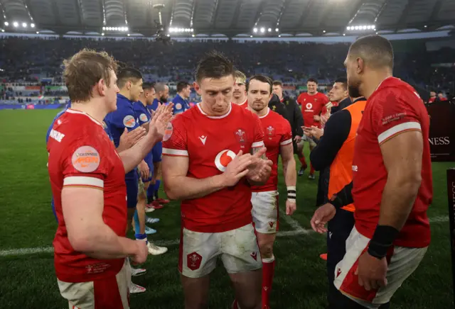 Dejected Wales players are clapped off the pitch