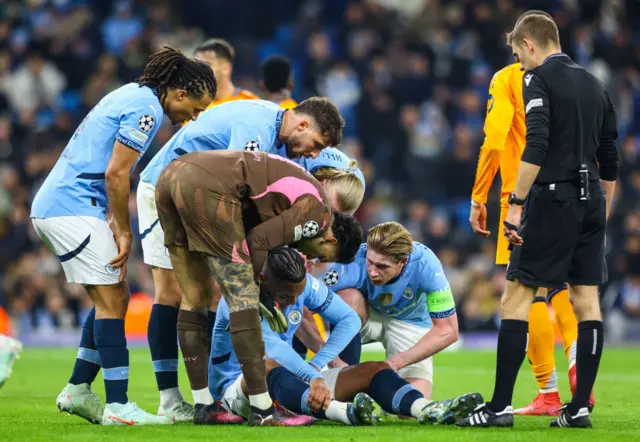 Akanji is surrounded by teammates as he sits on the turf at half time