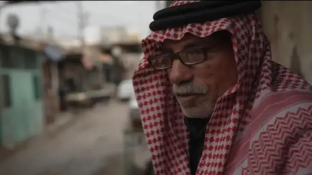 An elderly Jordanian man, with glasses and a keffiyeh, a type of headdress