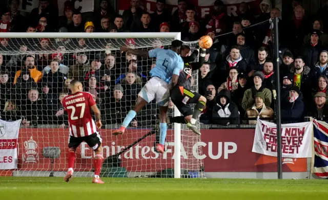 Nottingham Forest's Taiwo Awoniyi (centre left) and Exeter City's goalkeeper Joe Whitworth (centre right) battle for the ball during the Emirates FA Cup fourth round match at St James Park, Exeter.