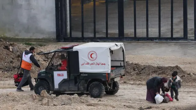 Members of the Palestine Red Crescent Society (PRCS) help Palestinians leave Nur Shams refugee camp, near the West Bank city of Tulkarem