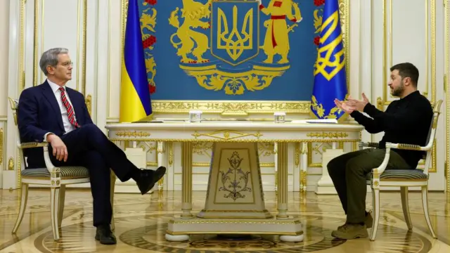 Ukraine's President Volodymyr Zelenskiy and US Secretary of the Treasury Scott Bessent sit opposite each other at a table