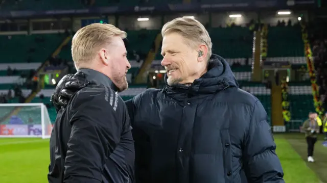 Celtic's Kasper Schmeichel speaks to his father Peter Schmeichel during the UEFA Champions League 2024/25 League Knockout Play-off first leg match between Celtic and FC Bayern Munich at Celtic Park