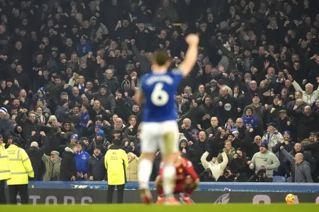 Tarkowski lifts his arm in salute to the home fans