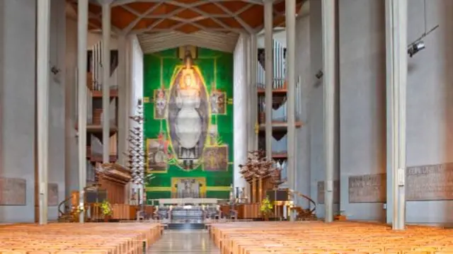 The nave of the cathedral, or the central part of the building, with a view of the tapestry, Christ in Glory, by Graham Sutherland.