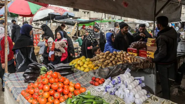 Pictures emerging from earlier today show dozens of people attending a market against the backdrop of a building destroyed during the Israel-Hamas war.