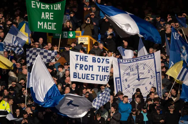 Everton fans wave flags and banners in the Gwladys street end