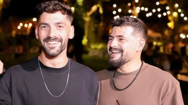 Ziv and Gali Berman are pictured in this family handout photo. They are identical twins, with dark curly hair and facial hair. One is wearing a black jump and the other is in a brown t-shirt. They are both wearing chain necklaces.