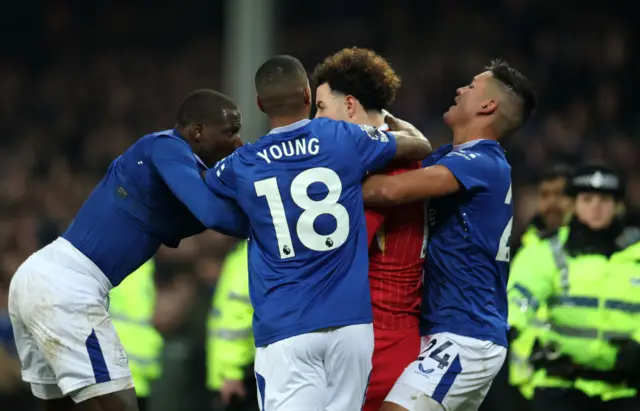 Jones is surrounded by Everton players after confronting Doucoure