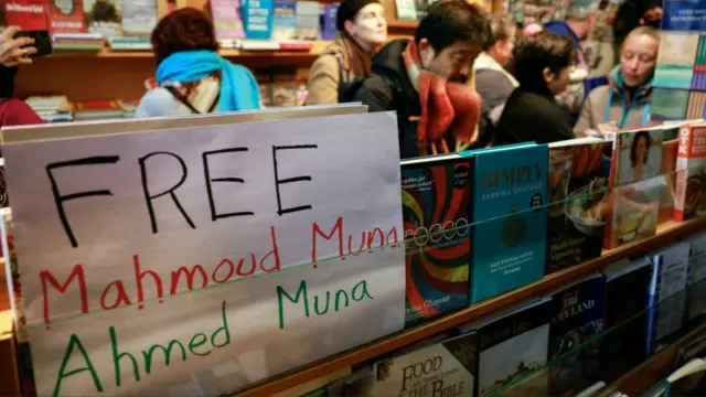 A sign written in the colours of the Palestinian flag is displayed in support of Mahmoud Muna and Ahmed Muna, as supporters attend an Educational Bookshop