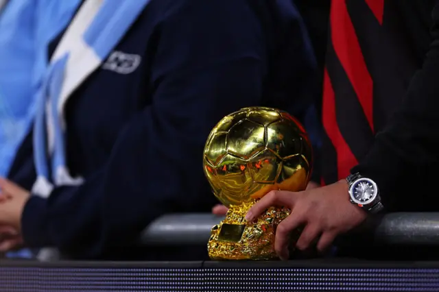 A fan holds a replica Ballon d'or